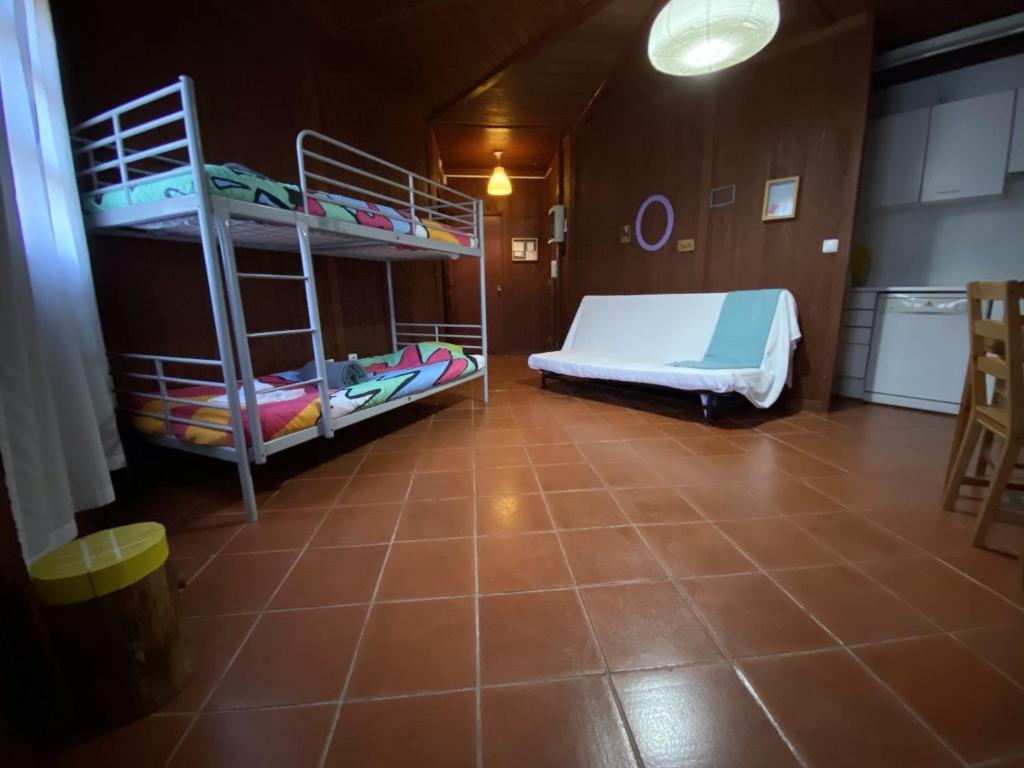 Habitación con 2 literas y suelo de baldosa. en YMCA Camp Alambre, en Azeitão