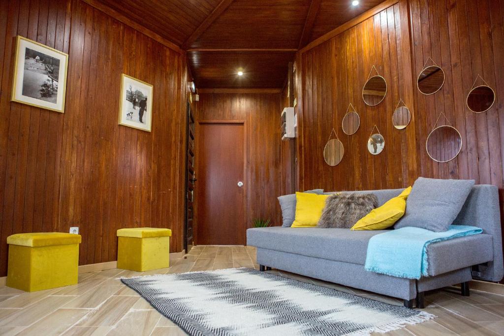 a living room with a couch and wooden walls at YMCA Camp Alambre in Azeitao