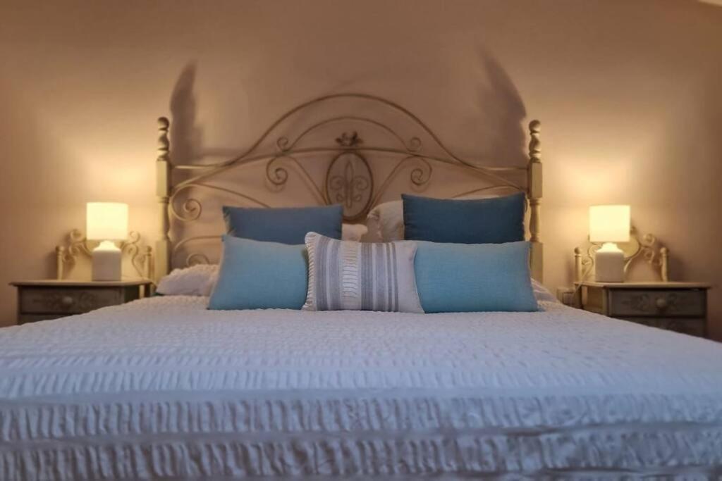 łóżko z biało-niebieskimi poduszkami i 2 lampami w obiekcie La Morada de Toledo w mieście Toledo