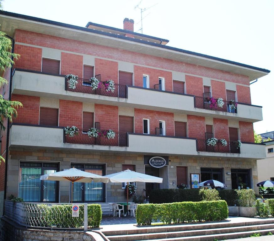 un edificio con dos sombrillas delante en Albergo "da Mario", en Pianoro