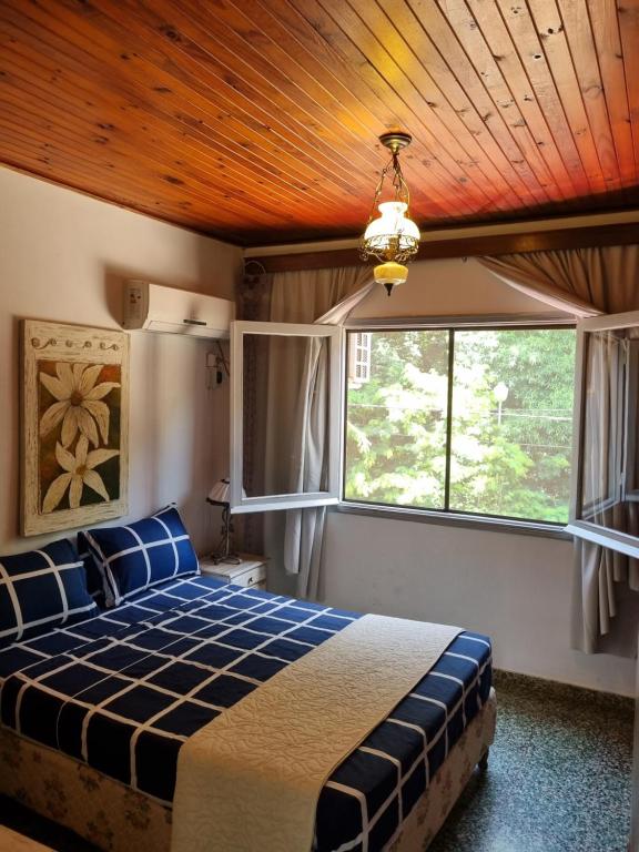 een slaapkamer met een bed en een houten plafond bij Acutí Departamento in Puerto Iguazú