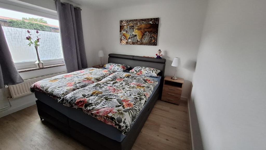 a bedroom with a bed with a floral comforter at Ferienwohnung Feldblick in Upahl