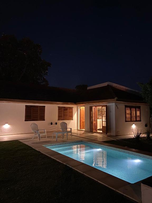 a swimming pool in front of a house at night at Casa Franklin, A media cuadra de la laguna! in Chascomús
