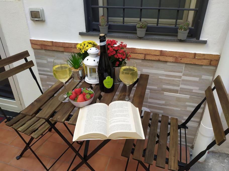 a table with an open book and glasses of wine at Andy's Home in Catania