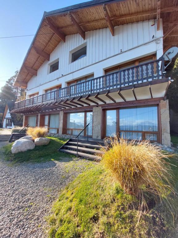 a house with a balcony on top of it at Bustillo 7500 in San Carlos de Bariloche
