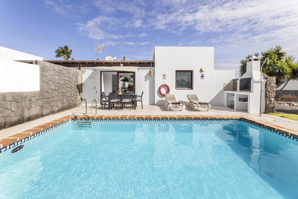 a swimming pool in front of a villa at Villa Bezanilla - VipVipVillas in Playa Blanca