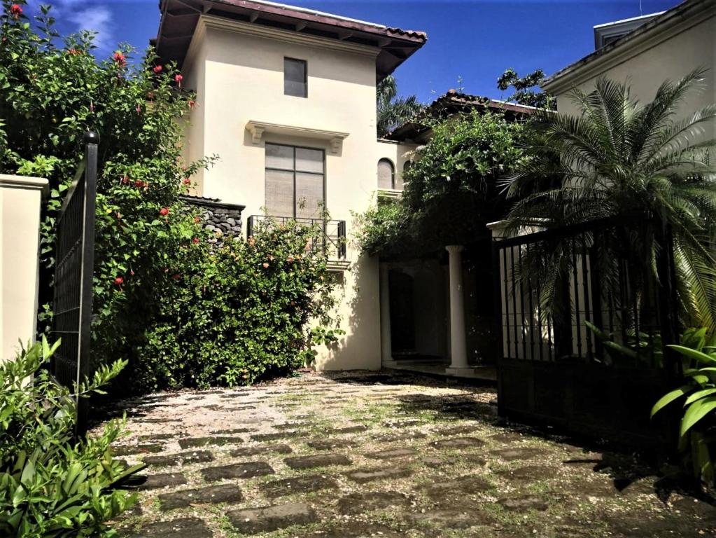 a house with a gate and a stone driveway at Typical villa , swimming pool, 300 Meters to Langosta Tamarindo beaches in Tamarindo