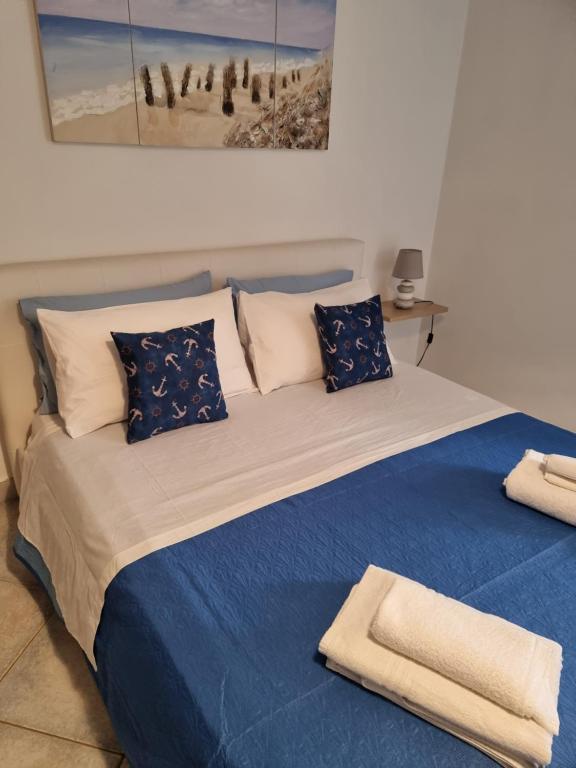 een slaapkamer met een bed met blauwe lakens en kussens bij B&B Casa Roel in Sant'Agnello
