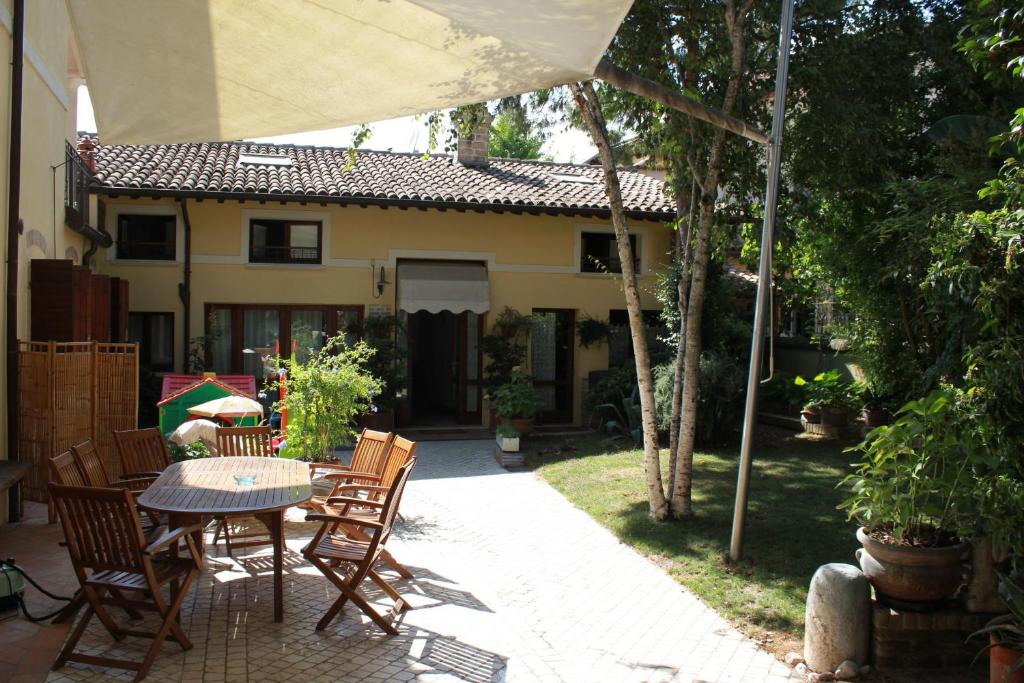 um pátio com uma mesa e cadeiras e uma casa em B&B Al Borgo em Ravenna