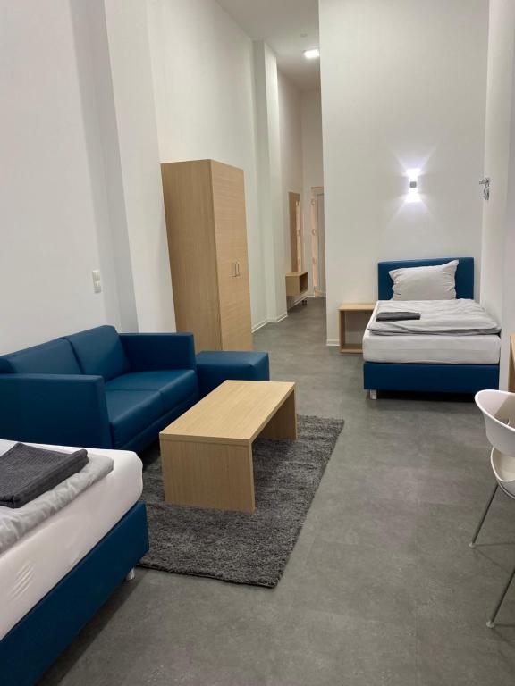 a room with two beds and a couch and a table at Fabella Flats Forchheim in Forchheim