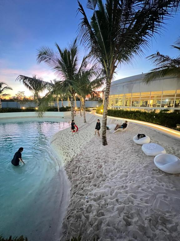 un gruppo di persone che giocano in acqua in un resort di Azure North Staycation by 7TwentySix CRIB a San Fernando