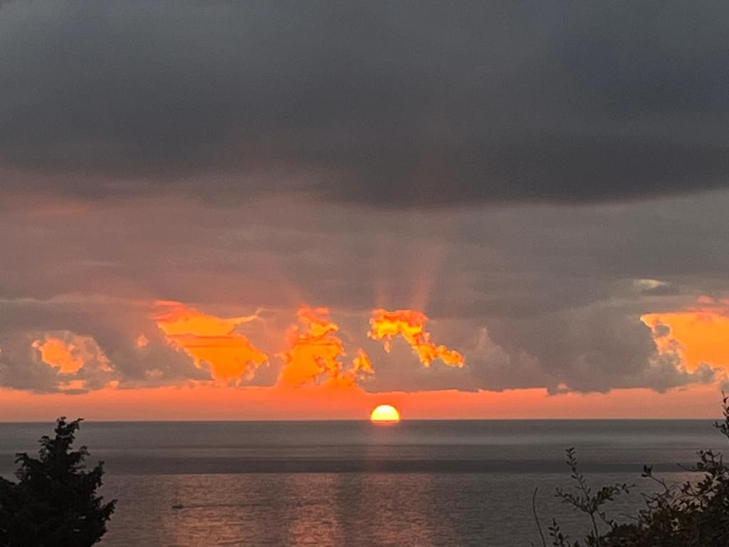 巴爾的住宿－SeaAdrik，太阳隐藏在云层后,在海洋上方的日落