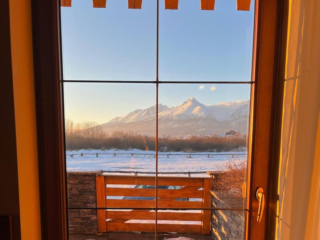 美國魯穆尼卡的住宿－Tri Štíty Apartment with Tatra View Terrace，透过窗户可欣赏到雪山的景色