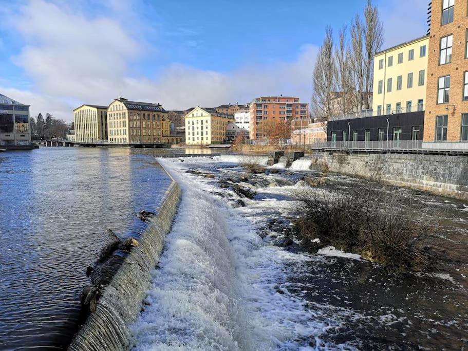 a river with snow and buildings in a city at Mysig lägenhet i City in Norrköping