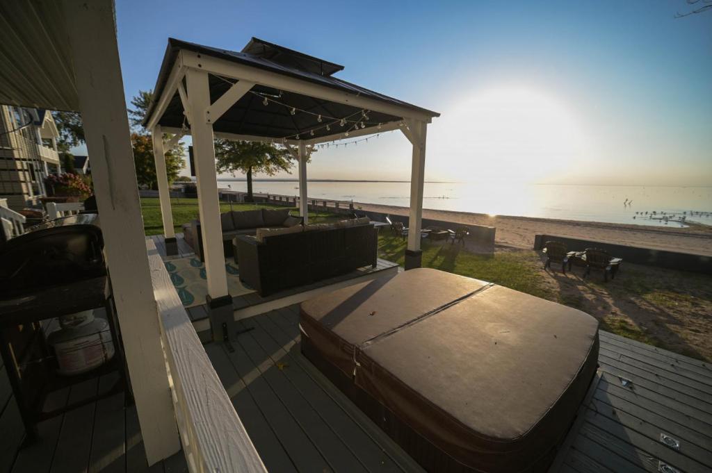 - un lit sur une terrasse à côté de la plage dans l'établissement The Historic Oneida Lake House - Condo 4, à Blossvale