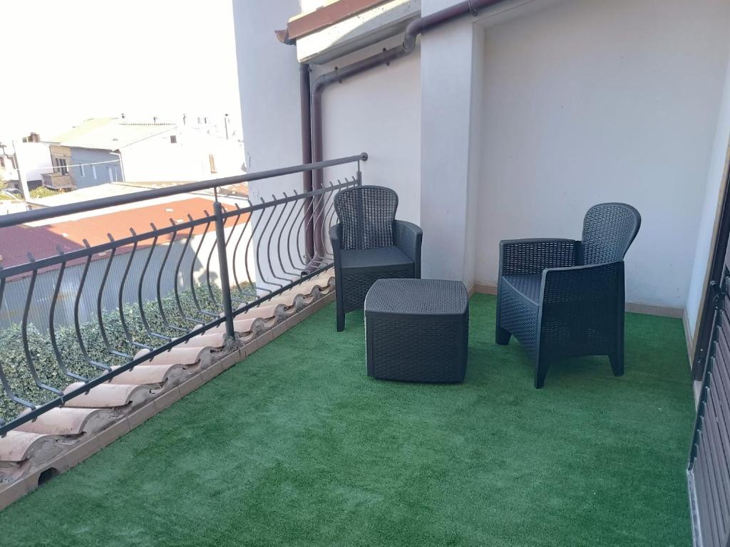 two chairs and a table on a balcony with green grass at B&B "LE LUCI" CAMERA IN ATTICO GRAN VISTA interno 4 in Vasto