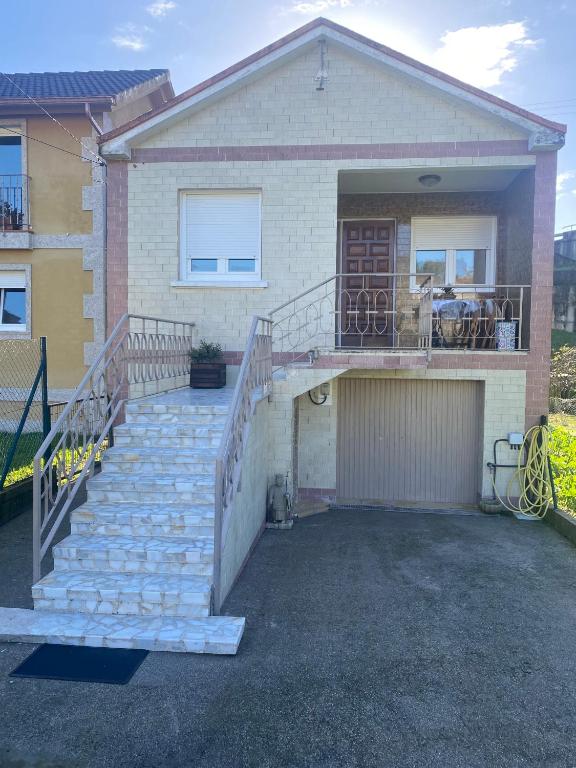 a house with a staircase leading to a garage at BAHIÑA MAR in Baiona