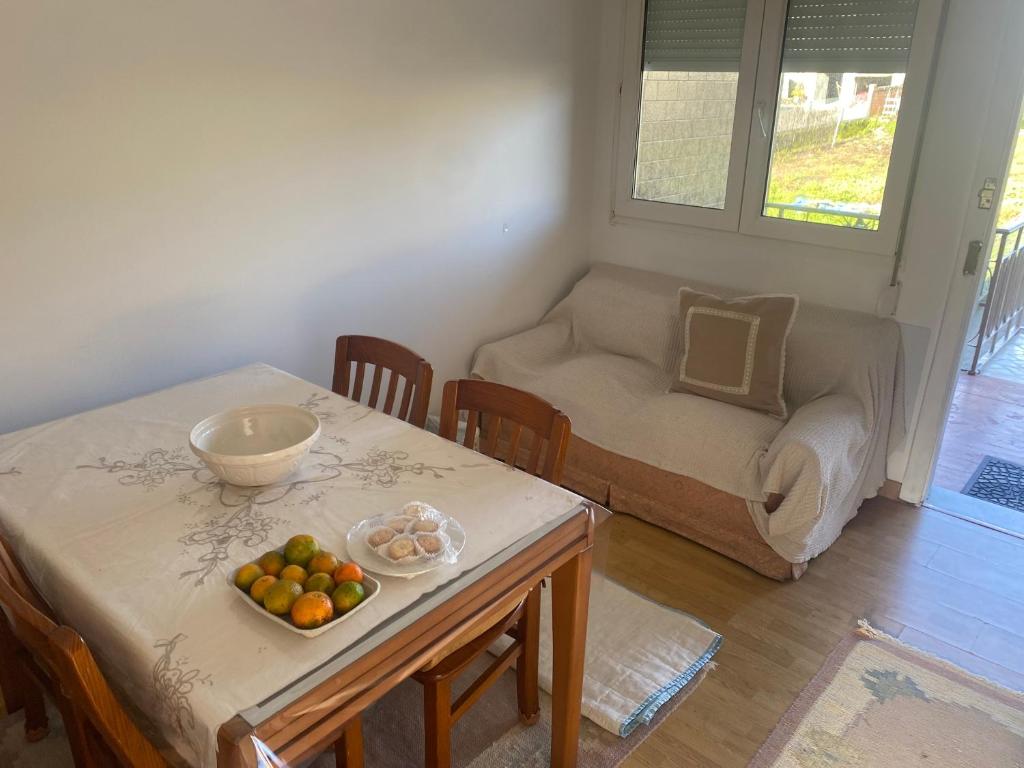 a living room with a table with a bowl of fruit on it at BAHIÑA MAR in Baiona