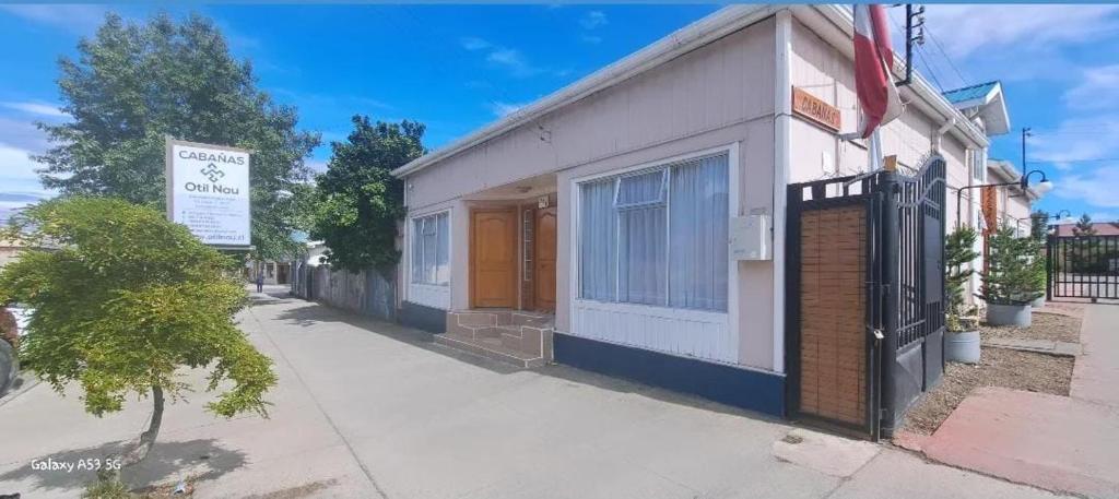 a building with a gate on the side of a street at Cabañas OtilNau in Puerto Natales