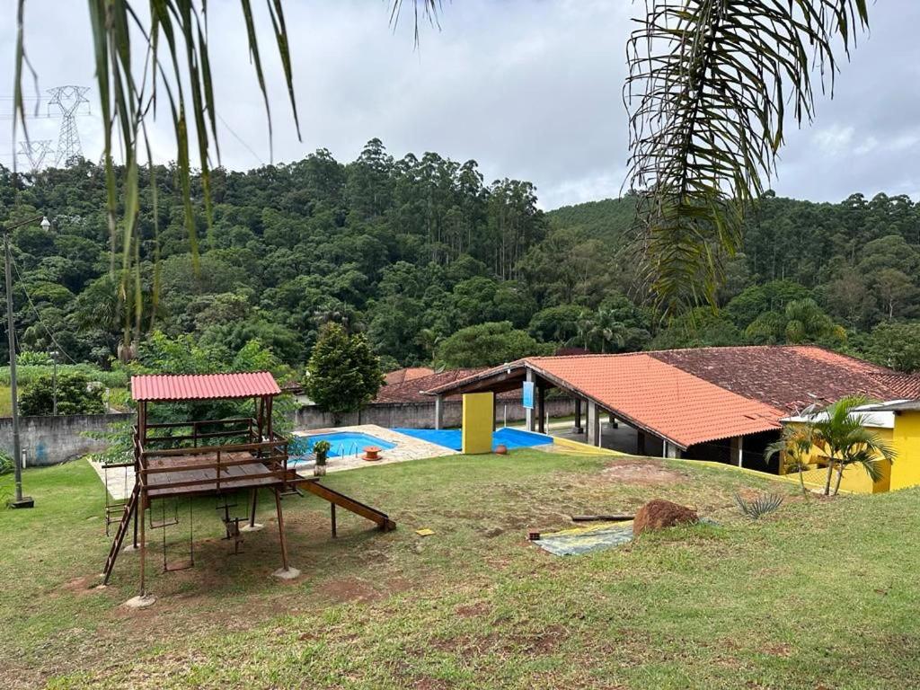 a yard with a playground and a house with a pool at Chácara em Guararema in Guararema