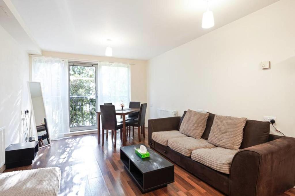 a living room with a couch and a table at Bright & Immense 2 BDR Flat near Excel Center in London
