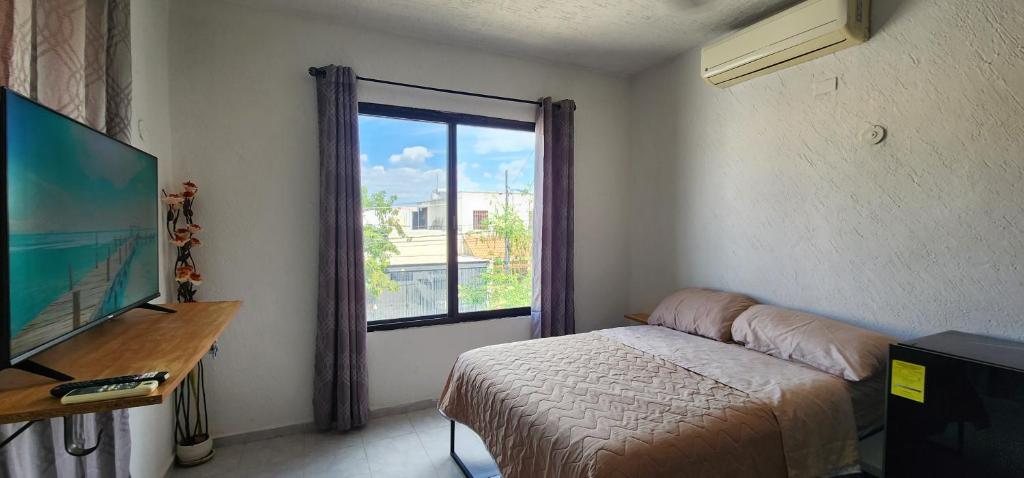 a bedroom with a bed and a large window at Piso completo. Hasta 9 personas. Norte MID in Mérida