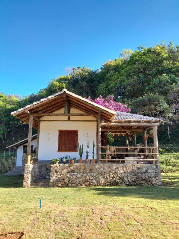 uma pequena casa com uma parede de pedra em Chalé das borboletas em Tiradentes