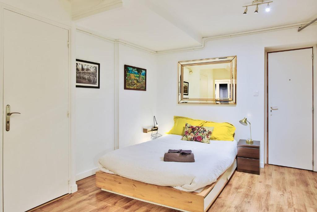 Un dormitorio con una cama con un espejo en la pared. en Cosy lyon Opera, en Lyon