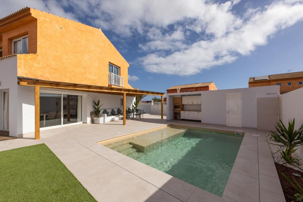 un cortile con piscina e una casa di Casa Nahia a Corralejo