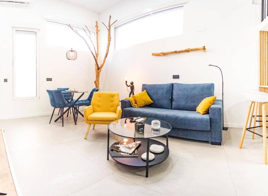 a living room with a blue couch and yellow chairs at Loft 11 A in Murcia