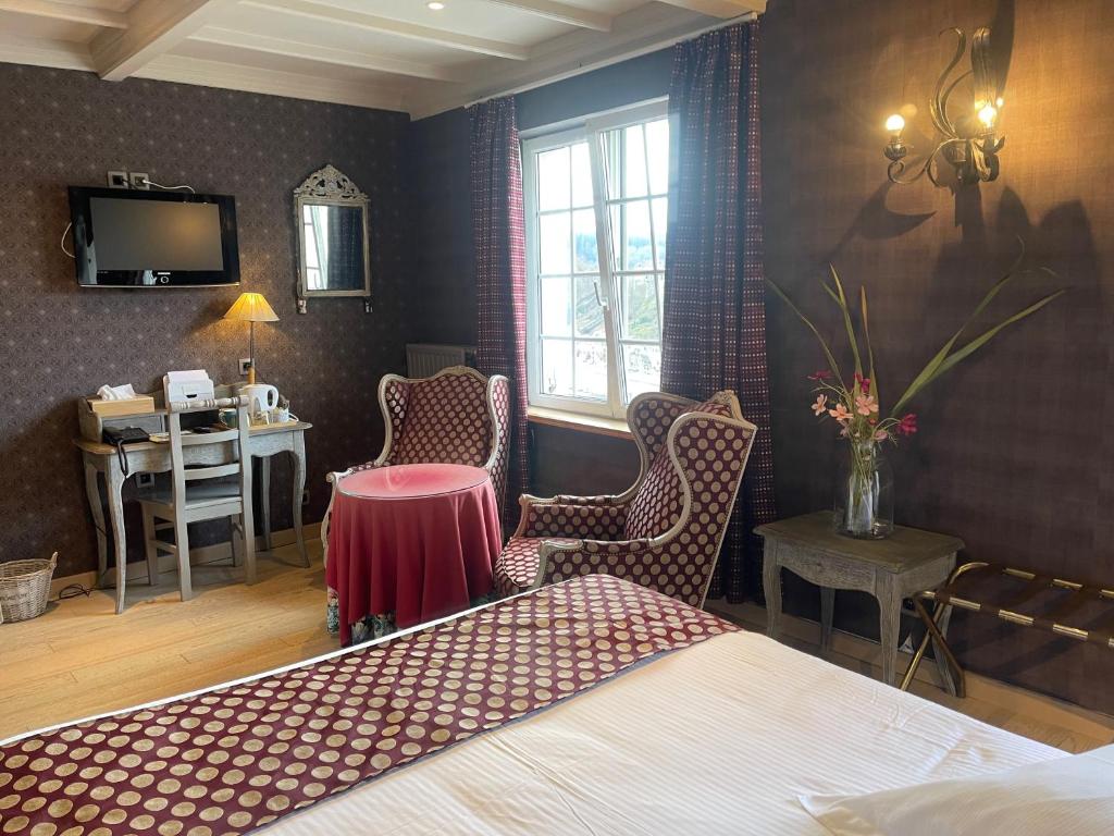Le Cosy Hotel Restaurant في بوالون: غرفة نوم بسرير وطاولة ومكتب