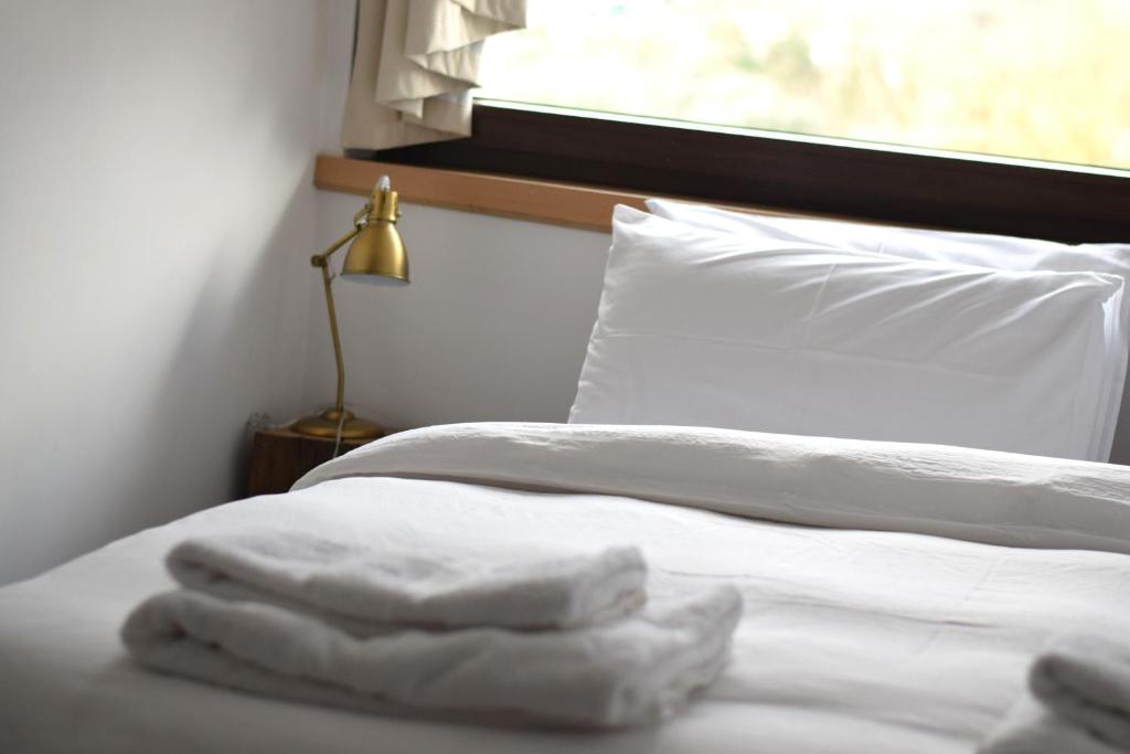 een slaapkamer met 2 bedden met witte lakens en een raam bij b&b Adamà in Atena Lucana