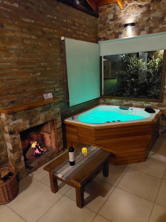 a jacuzzi tub in a room with a fireplace at CABAÑAS LOS ARRAYANES in Chascomús