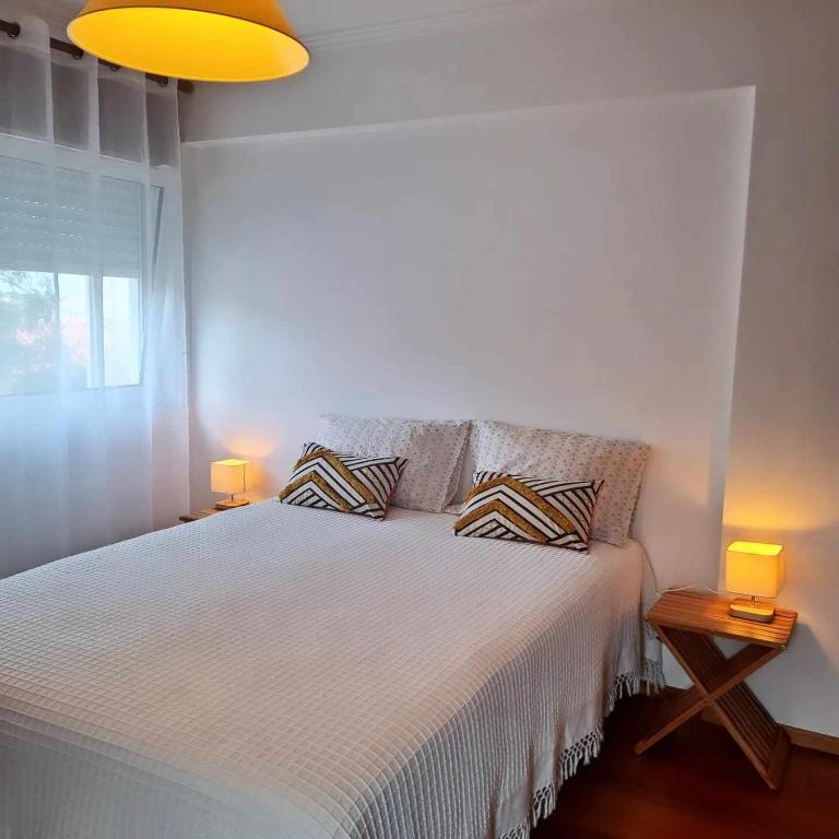 ein Schlafzimmer mit einem Bett mit zwei Kissen darauf in der Unterkunft Casa das Borboletas in Évora