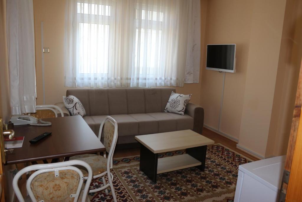 トラブゾンにあるGüler Central Apartmentのリビングルーム(ソファ、テーブル付)