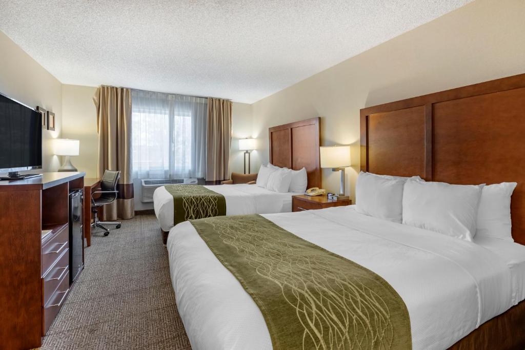 a hotel room with two beds and a flat screen tv at Comfort Inn Denver West Arvada Station in Wheat Ridge