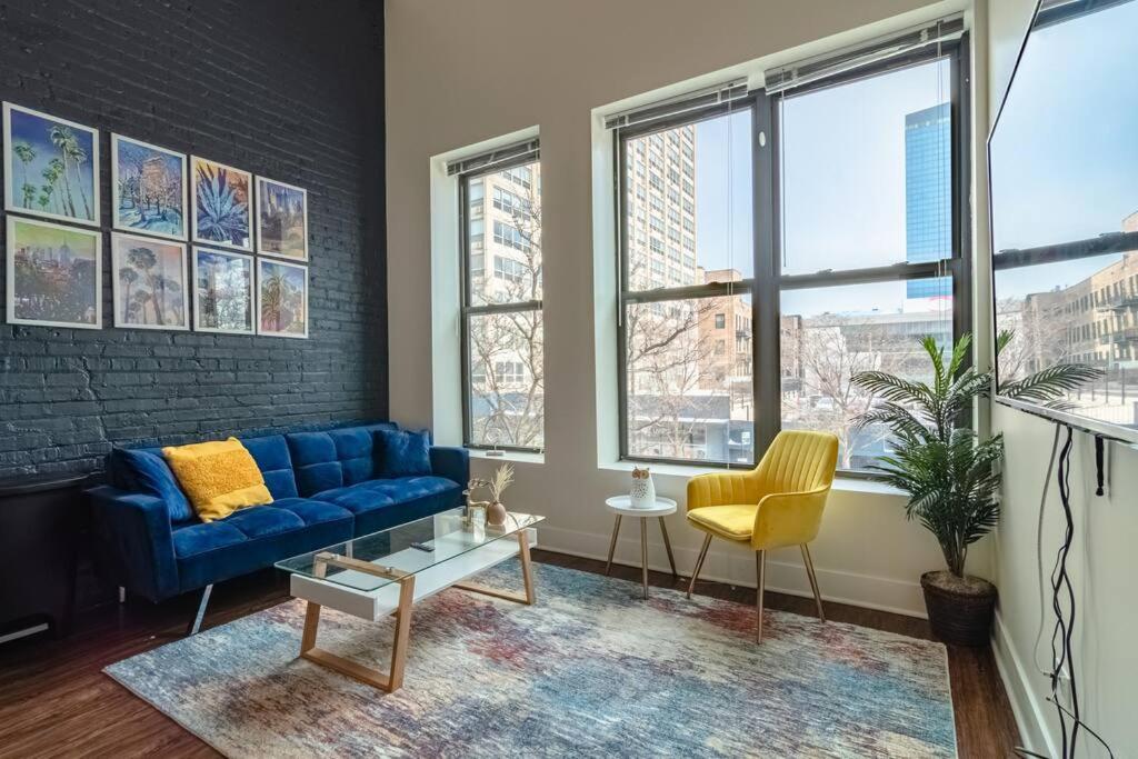 a living room with a blue couch and yellow chairs at McCormick Place 420 friendly 2br/2ba with optional parking for up to 6 guests in Chicago
