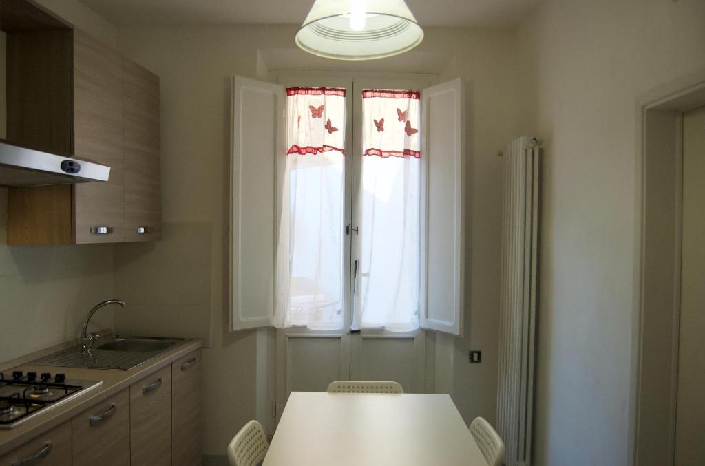 eine Küche mit einem weißen Tisch und einem Fenster in der Unterkunft Casa di Canfreo in Lari