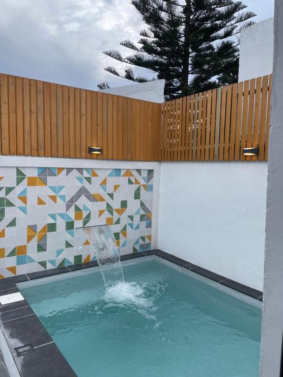 a swimming pool with a fountain and a fence at Casa de Santa Catarina - Ponta Delgada in Ponta Delgada