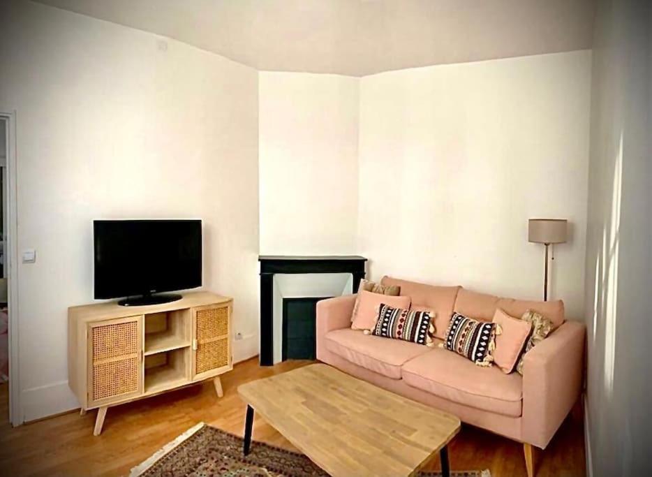 a living room with a couch and a flat screen tv at Très joli appartement à Puteaux centre ville in Puteaux