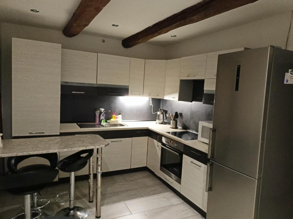 a kitchen with white cabinets and a stainless steel refrigerator at Rekreační dům u Elišky a Barušky in Krakovany