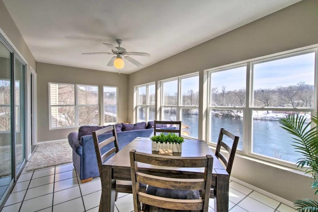 a dining room with a table and a couch and windows at Anglers Pointe in Branson