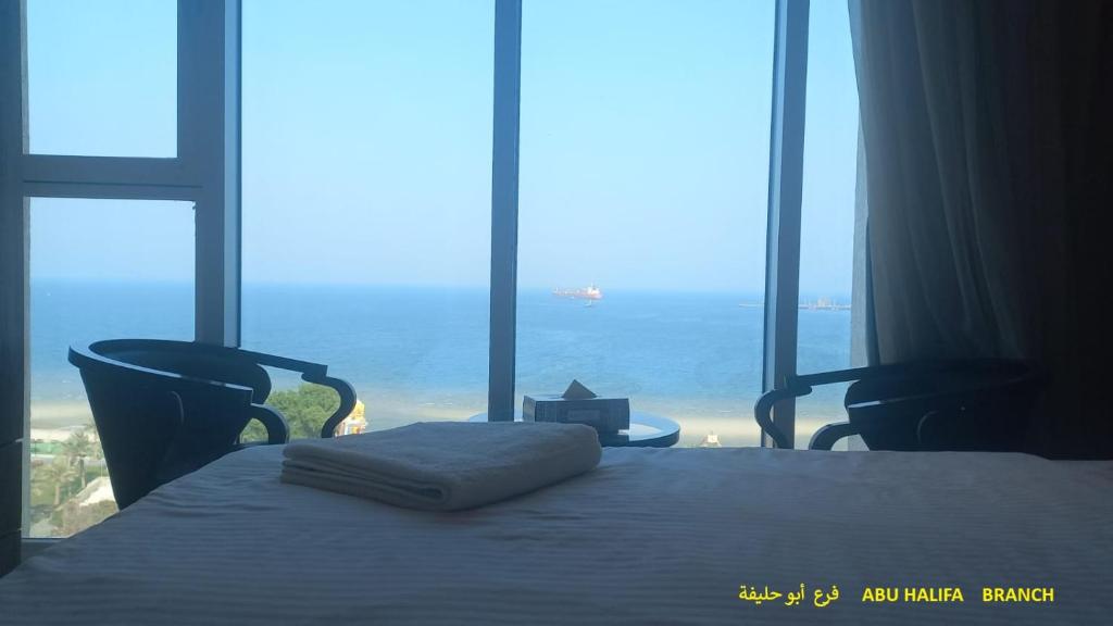 a bedroom with a bed with a view of the ocean at Blue Waves Abu Halifa أمواج الخليج الزرقاء in Kuwait