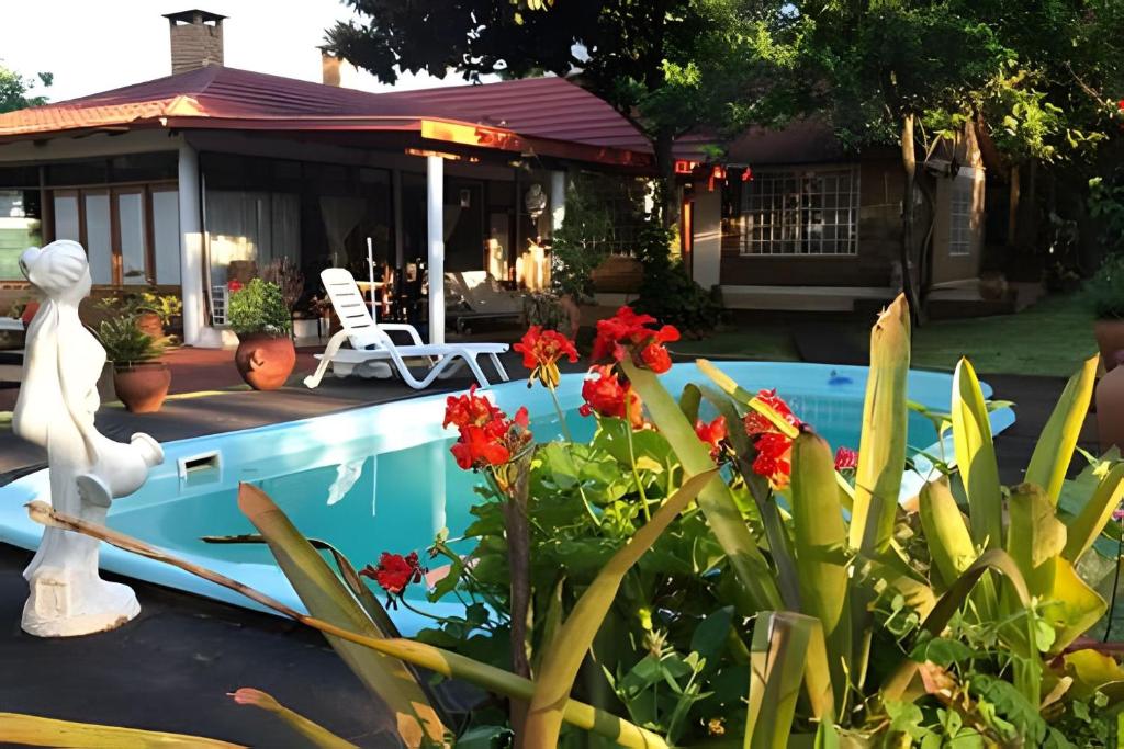 una casa con una piscina con flores rojas en Cabañas con piscina en la entrada de Oberá en Oberá