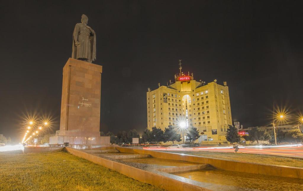 a large statue in front of a building with a building at Hotel Rustavi in Rustavi