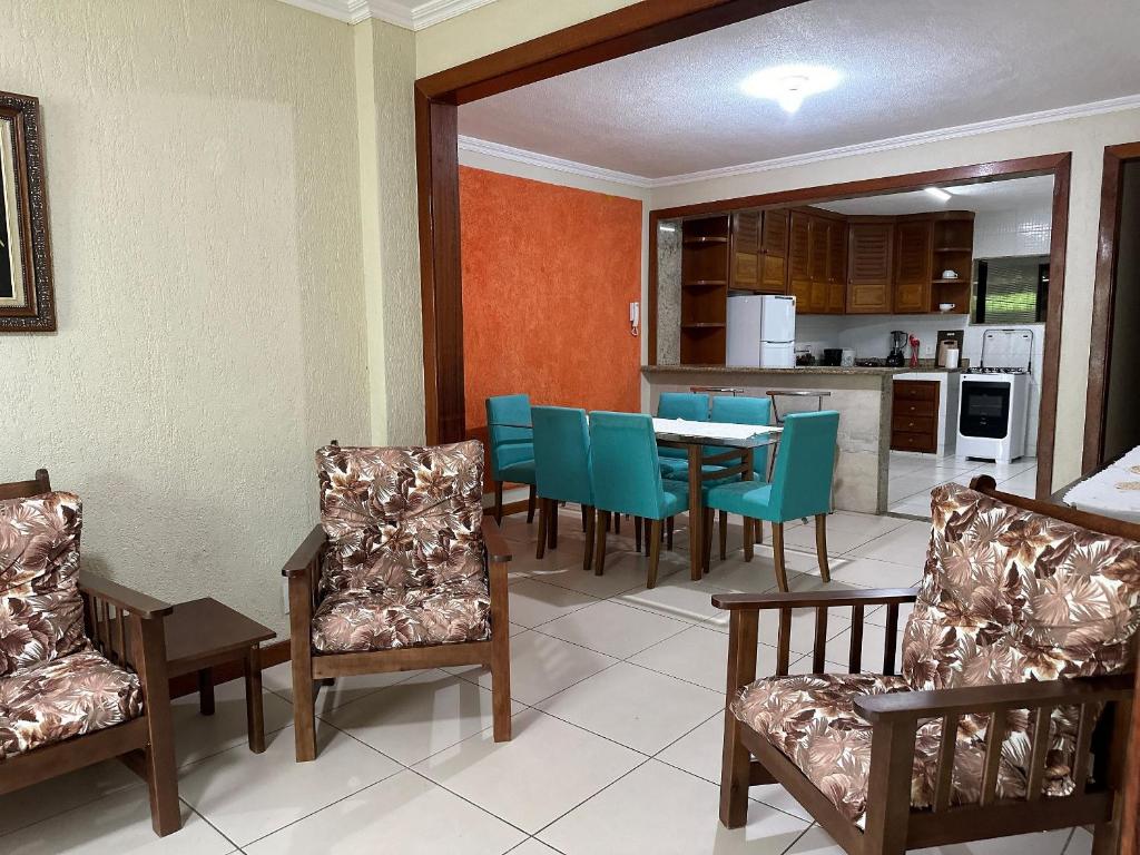 ein Esszimmer mit einem Tisch und Stühlen sowie eine Küche in der Unterkunft Apto acomchegante próximo a Praia do Bosque - 3 quartos - Ar condicionado - Garagem - TV Smart in Rio das Ostras