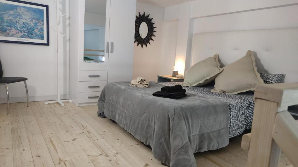 a bedroom with a bed and a mirror on the wall at Casa El Drago-TAFIRA BAJA in Las Palmas de Gran Canaria
