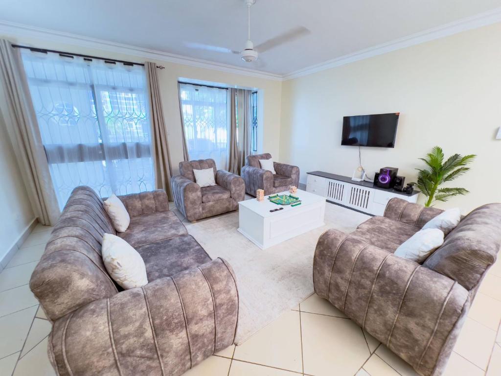 a living room with couches and a flat screen tv at Majestic Homes in Nyali