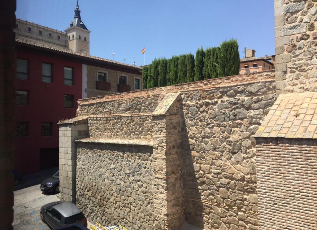 kamienna ściana z samochodem zaparkowanym obok w obiekcie Alojamiento en el centro de Toledo w mieście Toledo