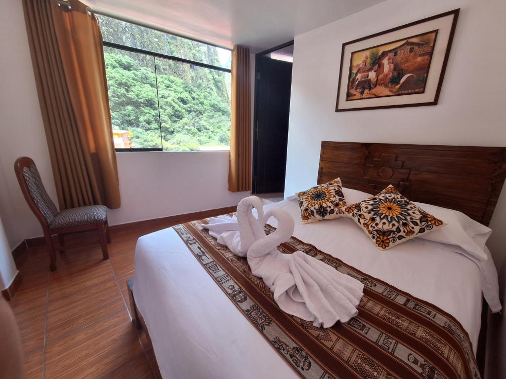 Un dormitorio con una cama con una toalla. en CUSI QOYLLOR en Machu Picchu